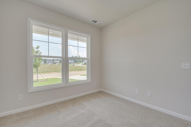 unfurnished room with carpet flooring, visible vents, and baseboards