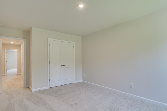 unfurnished bedroom featuring recessed lighting, light colored carpet, and baseboards