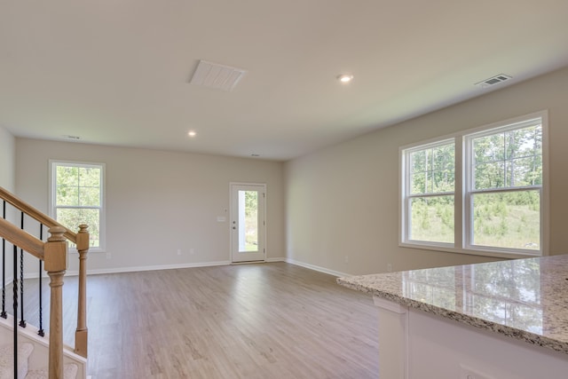 unfurnished living room with recessed lighting, stairway, baseboards, and light wood-style floors