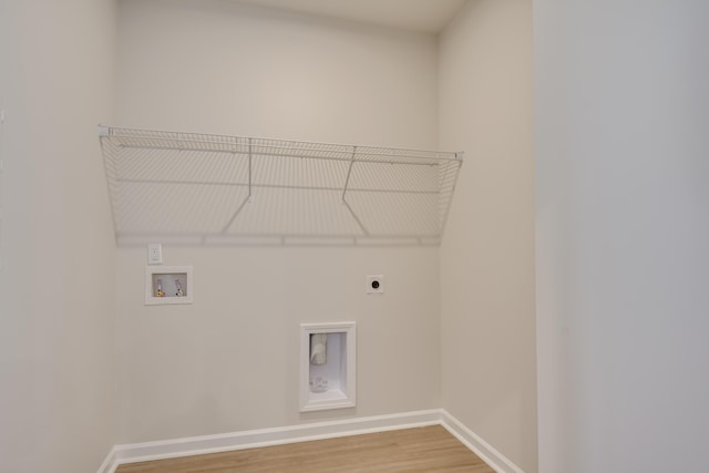 washroom featuring electric dryer hookup, washer hookup, wood finished floors, baseboards, and laundry area