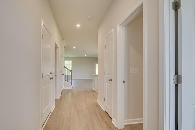 hall with recessed lighting, light wood-style flooring, and baseboards
