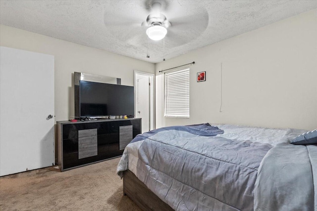 carpeted bedroom featuring ceiling fan and a textured ceiling