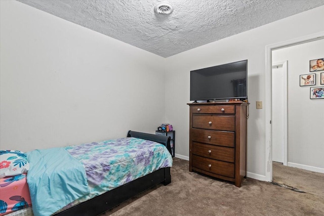 bedroom featuring light colored carpet and a textured ceiling