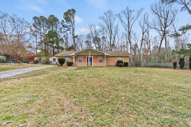 ranch-style home featuring a front lawn and covered porch