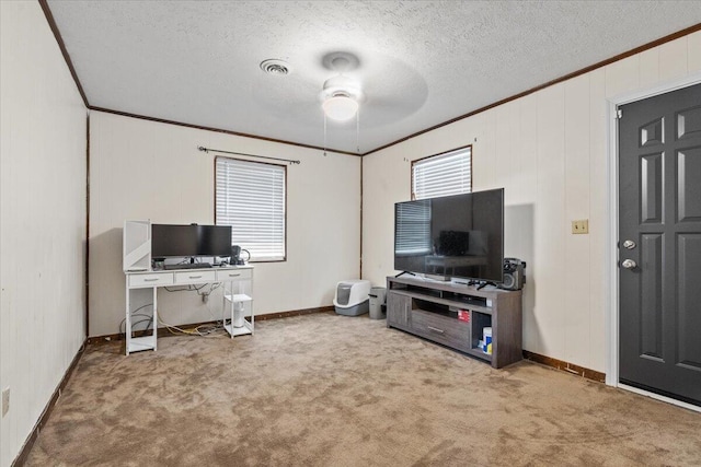 carpeted office space featuring plenty of natural light, crown molding, and ceiling fan