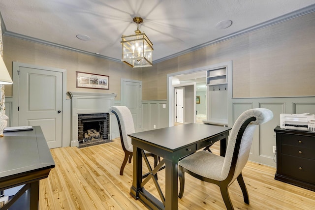 574 SW Newberry St, Aiken, SC 29801 - dining space with a decorative wall, a chandelier, a fireplace, light wood-style flooring, and wainscoting