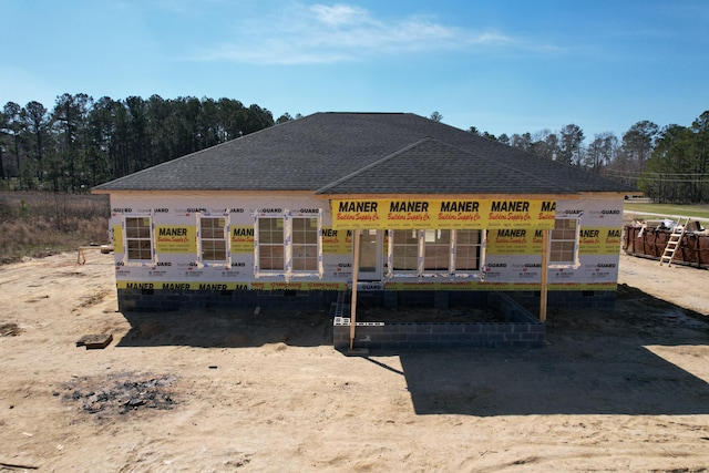 back of house with roof with shingles