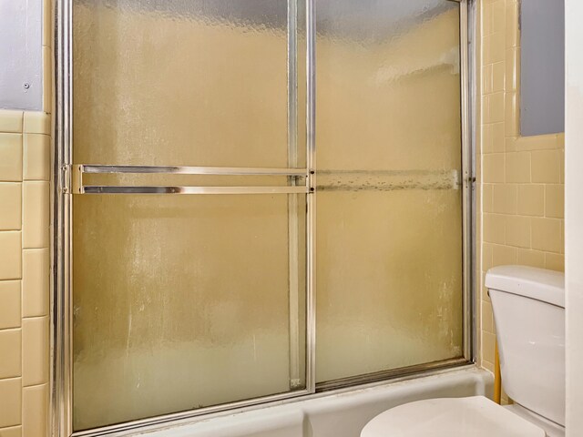 10236 S Ga Highway 23, Girard, GA 30426 - bathroom with combined bath / shower with glass door, toilet, and tile walls