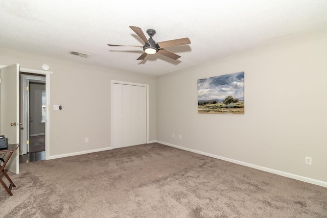 unfurnished room with ceiling fan, carpet, and a textured ceiling