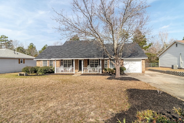 view of front facade with a garage, a front yard, central air condition unit, and a porch