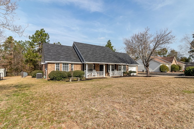 view of front of house with central AC, a front yard, and covered porch