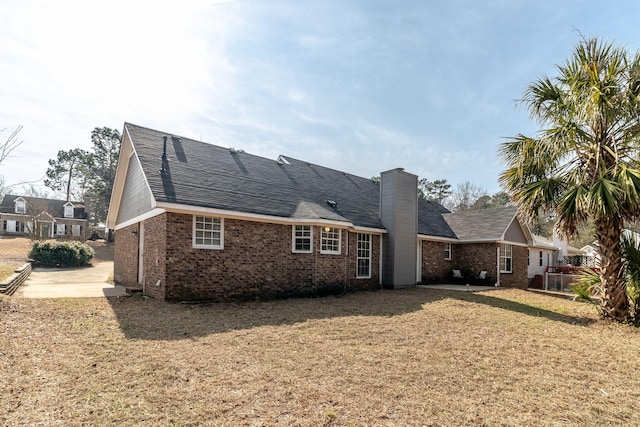 rear view of property featuring a lawn and a patio