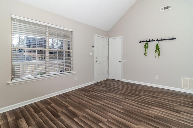 entrance foyer with high vaulted ceiling and dark hardwood / wood-style floors