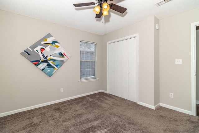 unfurnished bedroom with ceiling fan, carpet floors, a closet, and a textured ceiling