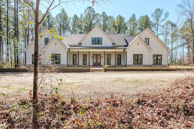 modern farmhouse featuring board and batten siding, french doors, covered porch, and a shingled roof