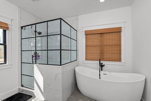 bathroom featuring a freestanding bath and a shower stall