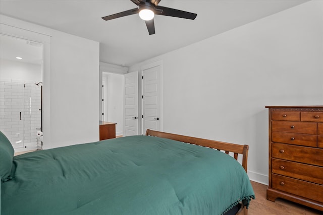 bedroom featuring ceiling fan, baseboards, wood finished floors, and ensuite bathroom