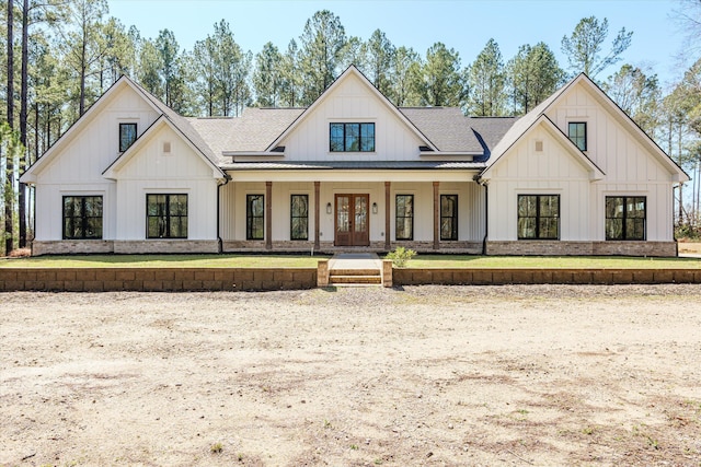 modern farmhouse style home featuring french doors, board and batten siding, and roof with shingles