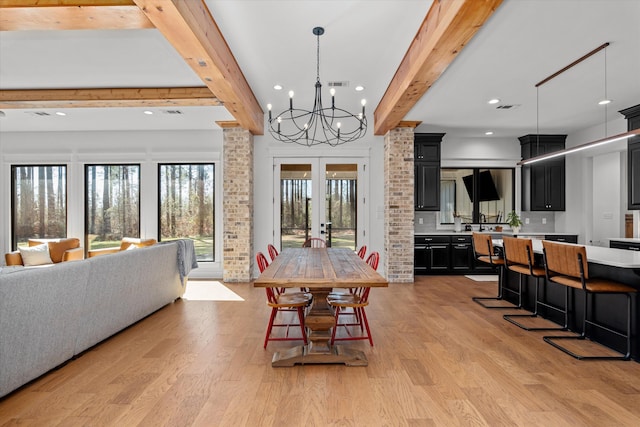 dining area with visible vents, an inviting chandelier, light wood-style floors, french doors, and beamed ceiling