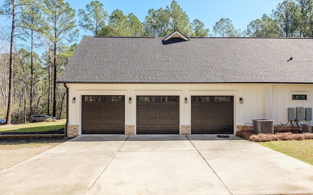 garage with cooling unit and concrete driveway