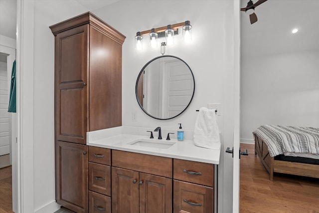 bathroom with vanity, wood finished floors, and baseboards