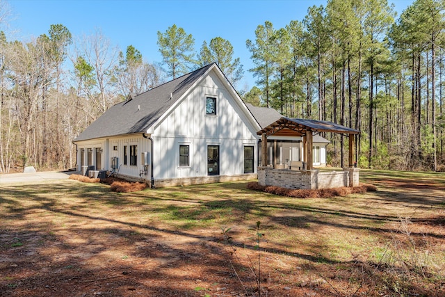 exterior space featuring board and batten siding, a shingled roof, concrete driveway, a lawn, and an attached garage