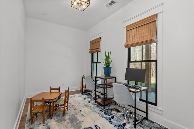 office area featuring wood finished floors, visible vents, and baseboards