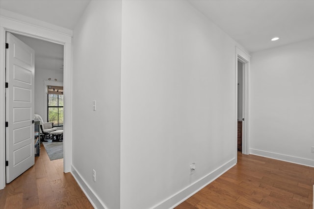 hall featuring recessed lighting, baseboards, and wood finished floors