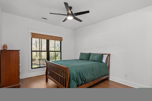 bedroom with visible vents, ceiling fan, baseboards, and wood finished floors