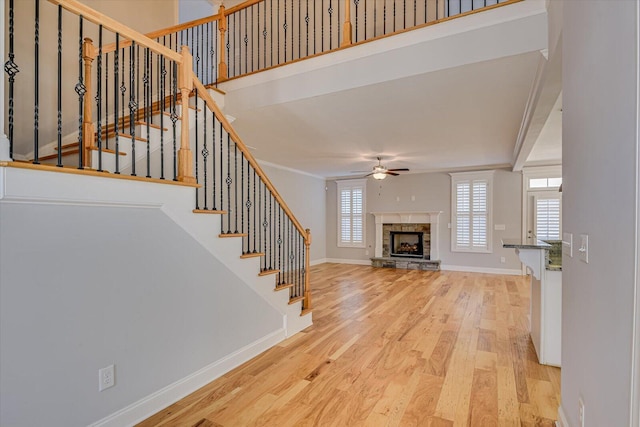 824 Brasstown Ct, Evans, GA 30809 - unfurnished living room featuring a ceiling fan, wood finished floors, a stone fireplace, and stairs