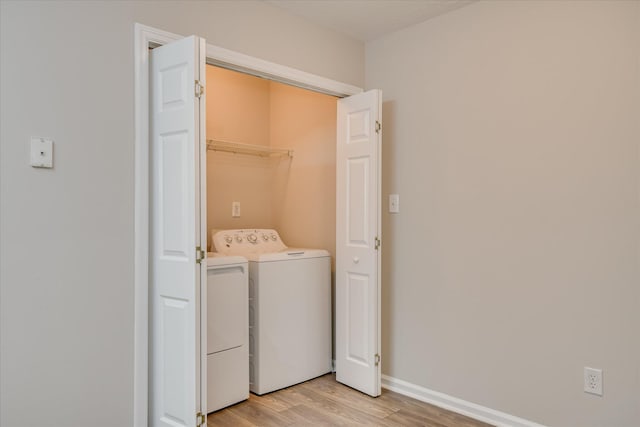 laundry room with laundry area, light wood finished floors, independent washer and dryer, and baseboards