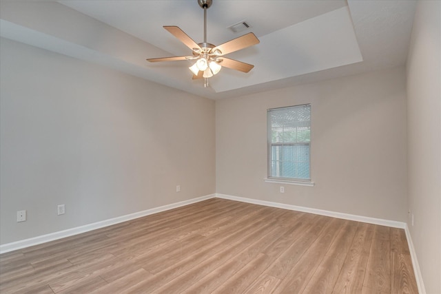 spare room with visible vents, a ceiling fan, light wood-style flooring, and baseboards