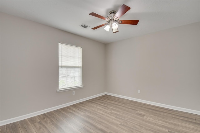 empty room with visible vents, a ceiling fan, baseboards, and light wood-type flooring