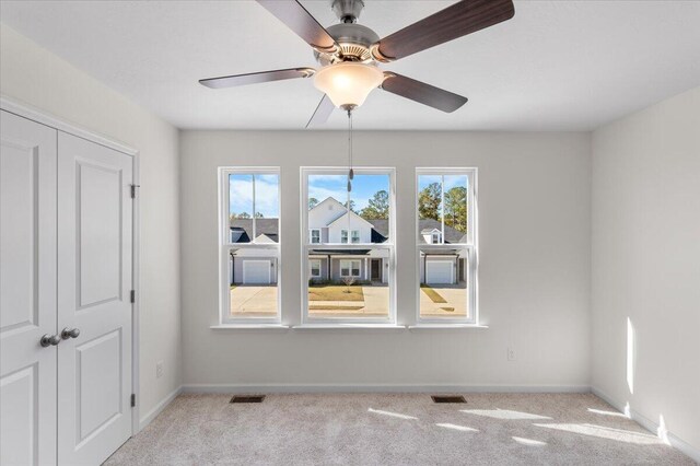 unfurnished room featuring ceiling fan and light carpet