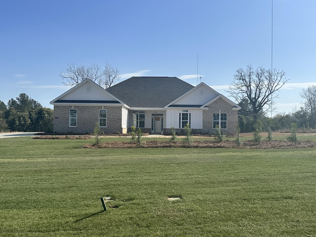 view of front of house featuring brick siding and a front lawn