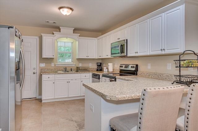 6005 Village W Ln, Graniteville, SC 29829 - kitchen with appliances with stainless steel finishes, a peninsula, and white cabinetry