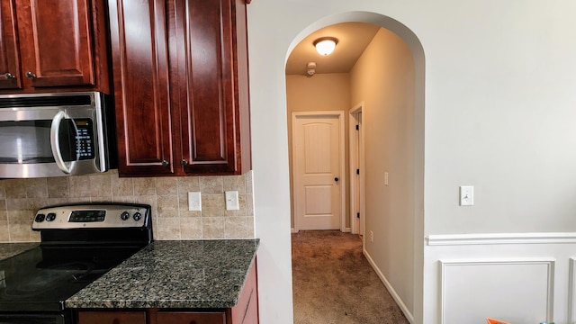 2806 Huntcliffe Dr, Augusta, GA 30909 - kitchen with appliances with stainless steel finishes, arched walkways, reddish brown cabinets, backsplash, and carpet floors