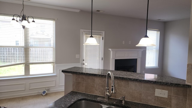 2806 Huntcliffe Dr, Augusta, GA 30909 - kitchen featuring a chandelier, dark stone countertops, wainscoting, a fireplace, and pendant lighting