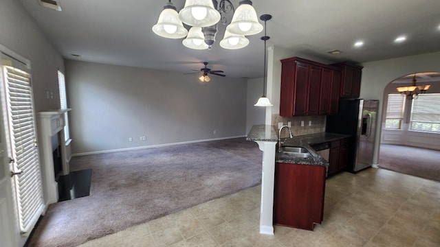 2806 Huntcliffe Dr, Augusta, GA 30909 - kitchen with a chandelier, reddish brown cabinets, light carpet, appliances with stainless steel finishes, and arched walkways