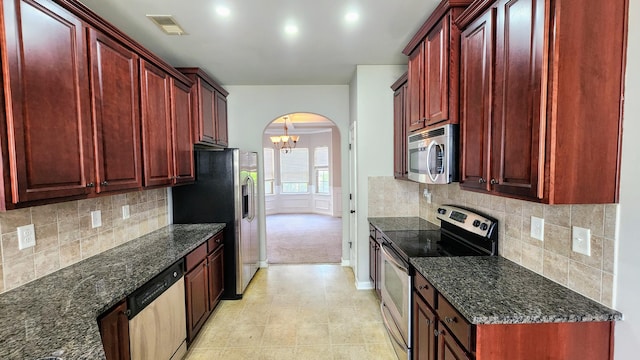 2806 Huntcliffe Dr, Augusta, GA 30909 - kitchen with stainless steel appliances, dark brown cabinets, arched walkways, and dark stone countertops