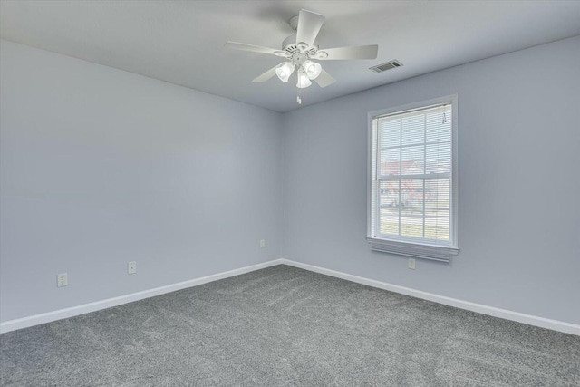 empty room with carpet floors, visible vents, baseboards, and a ceiling fan