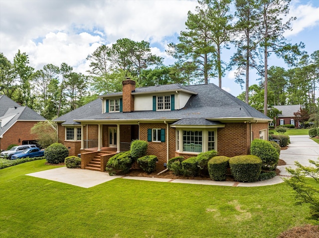 714 Jones Crk, Evans, GA 30809 - view of front facade featuring a front yard, a chimney, brick siding, and a shingled roof