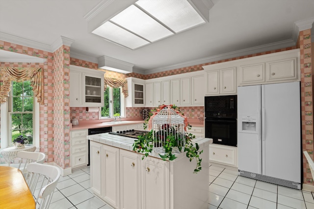 714 Jones Crk, Evans, GA 30809 - kitchen with black appliances, light tile patterned floors, tile counters, a center island, and ornamental molding