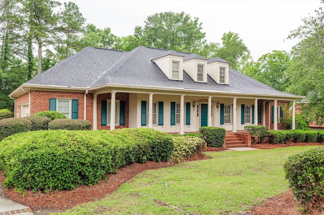 714 Jones Crk, Evans, GA 30809 - view of front of house featuring a porch, brick siding, a front lawn, a shingled roof, and stucco siding