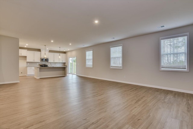 unfurnished living room with baseboards, recessed lighting, visible vents, and light wood-style floors