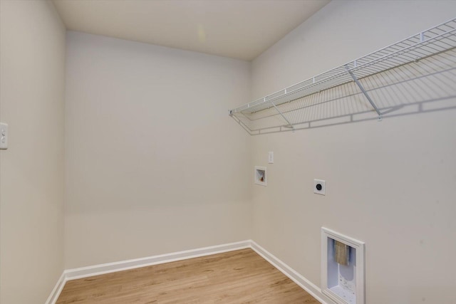 clothes washing area featuring hookup for an electric dryer, laundry area, washer hookup, baseboards, and light wood-style floors