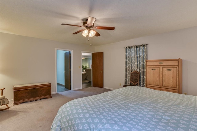 bedroom with a textured ceiling, ceiling fan, light carpet, and ensuite bath