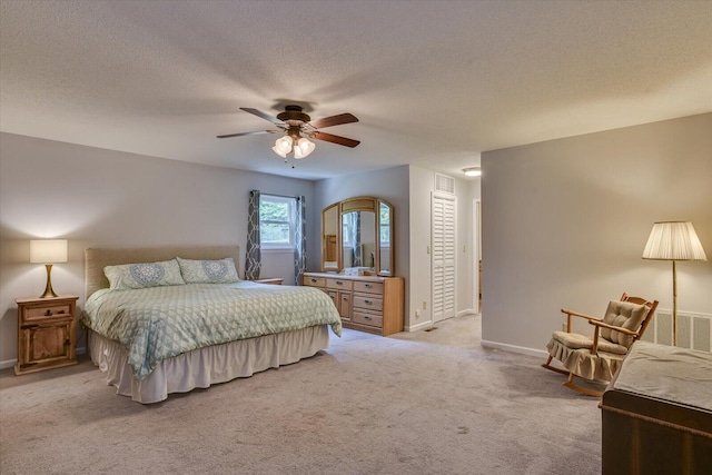 carpeted bedroom featuring ceiling fan and a textured ceiling