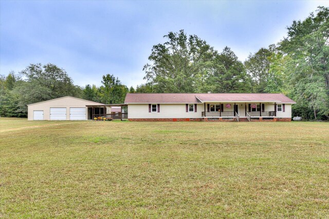 single story home with covered porch, a garage, an outdoor structure, and a front yard