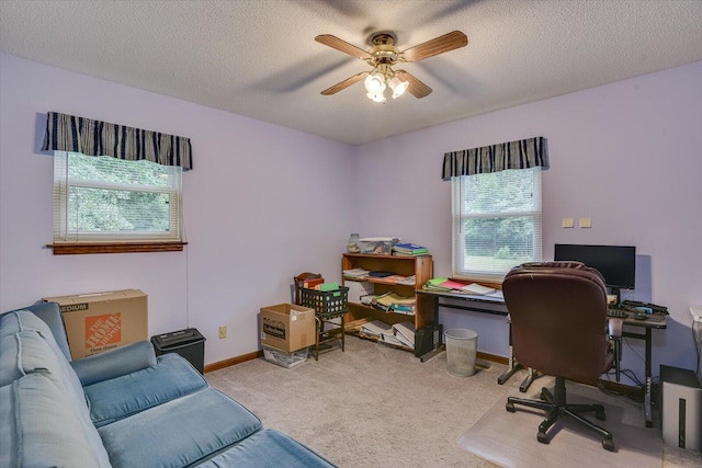 carpeted office featuring ceiling fan and a textured ceiling